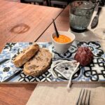 Gruss aus der Küche: Baumussbrot, hausgemachte Chorrizo und Aioli mit Tomaten Gruss aus der Küche: Baumussbrot, hausgemachte Chorrizo und Aioli mit Tomaten